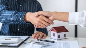 A couple compares a monthly housing budget beside a rental listing and a home purchase worksheet.